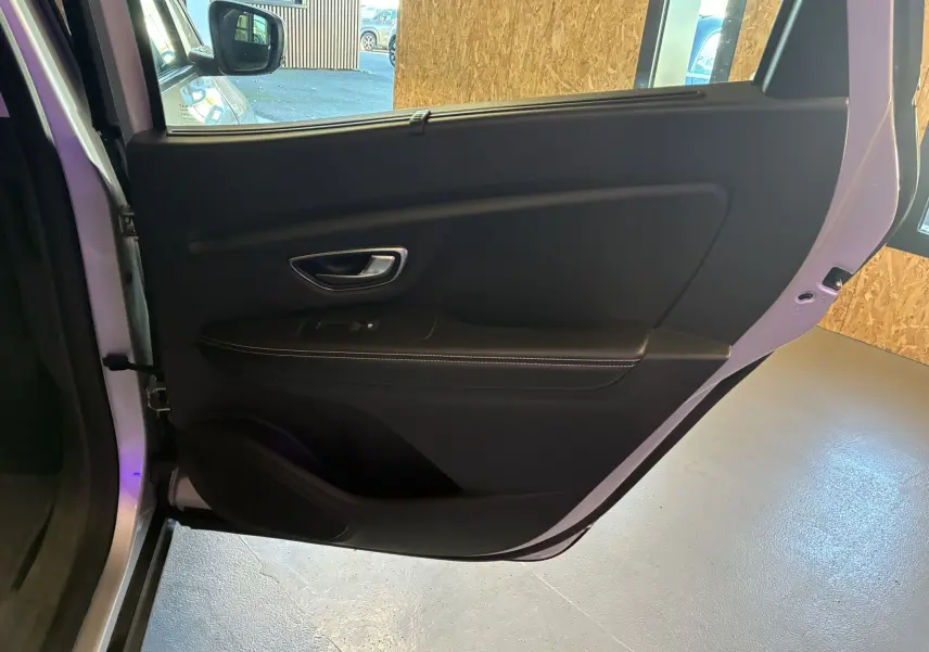 Porte arrière droite ouverte du Renault Grand Scenic gris 2017, intérieur noir avec poignée et commande de vitre visible.