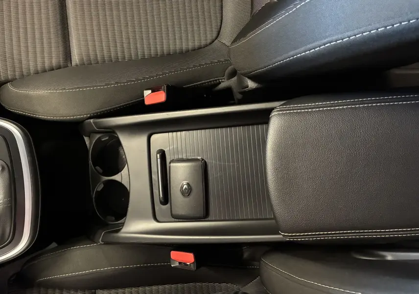 Vue plongeante sur la console centrale noire et les sièges en tissu gris du Renault Grand Scenic 2017.