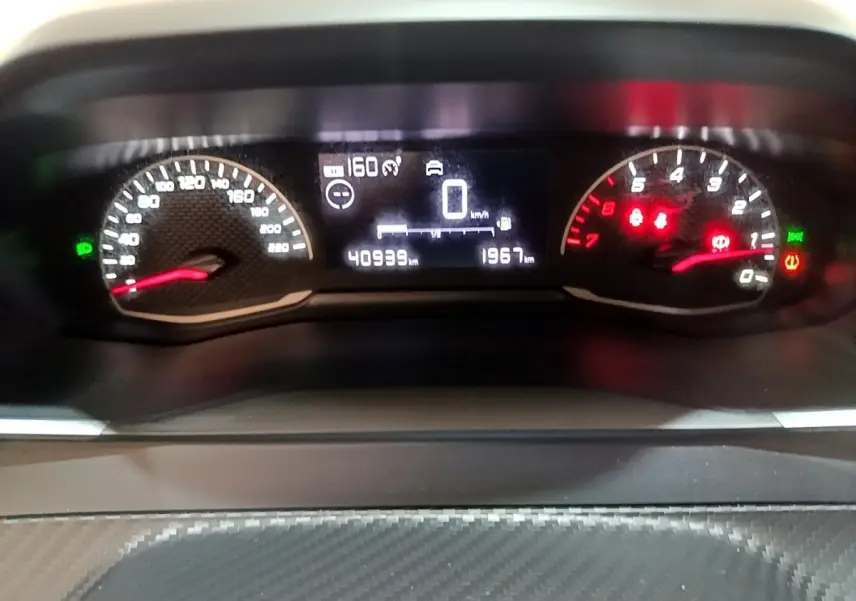 Tableau de bord numérique de la Peugeot 208 Diesel 2022, affichage vitesse et compte-tours en gros plan.