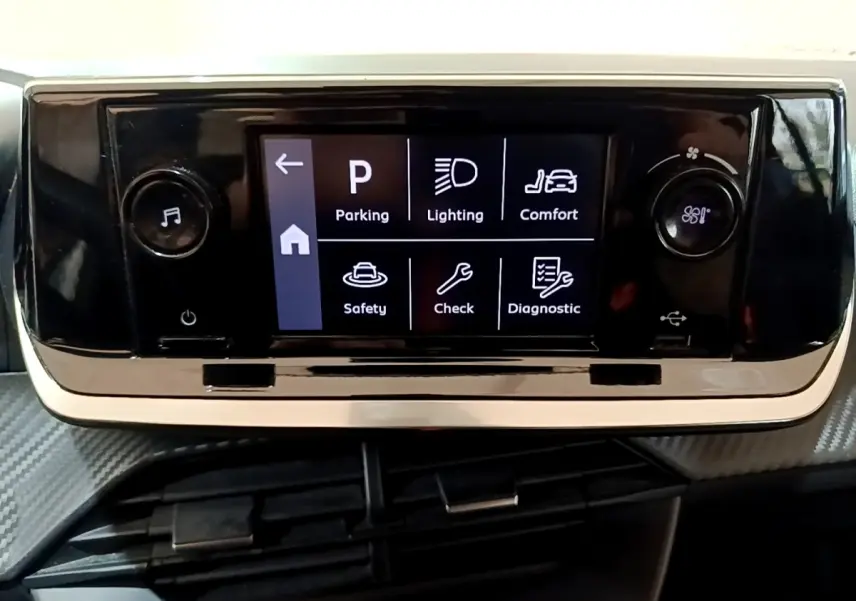 Écran tactile central noir affichant les options de conduite dans l'habitacle d'une Peugeot 208 blanche.