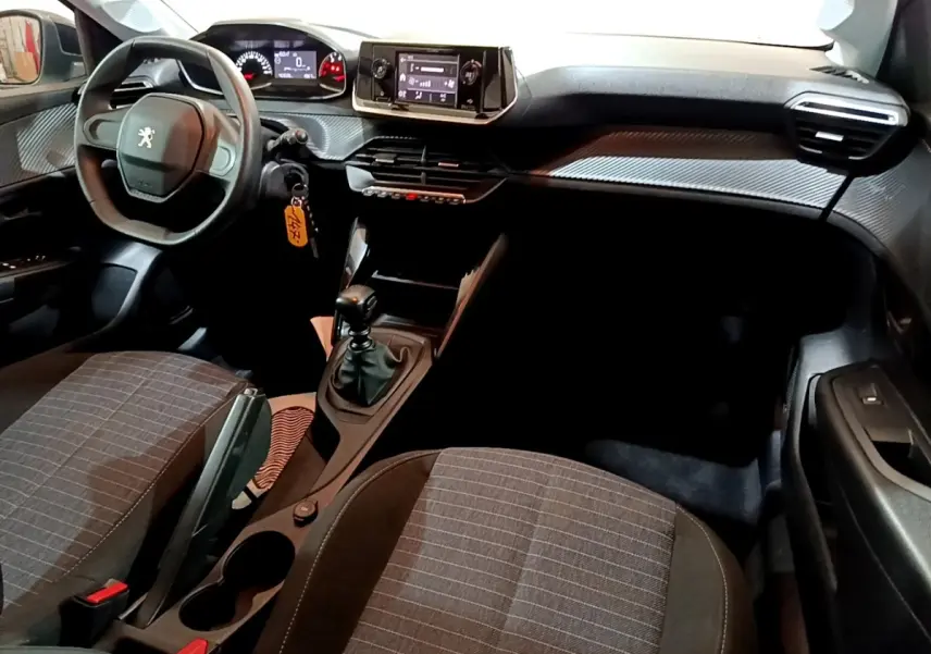 Intérieur de la Peugeot 208 1.5 BlueHDi 2022 vu côté conducteur, tableau de bord avec écran tactile et volant compact noir.