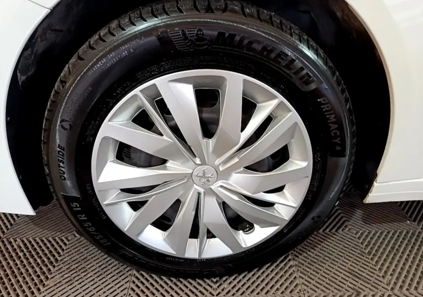Gros plan sur la roue avant droite blanche d'une Peugeot 208 1.5 BlueHDi 100 avec jante en alliage et pneu Michelin.