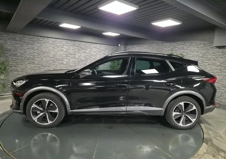 Vue de profil côté gauche du CUPRA Formentor noir avec jantes alliage et détails gris contrastants sur les bas de caisse.