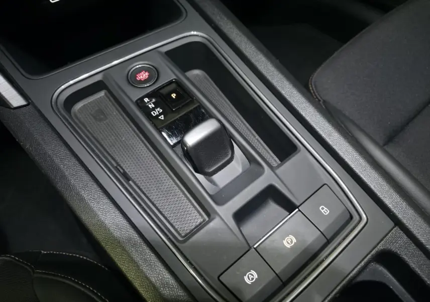 Gros plan sur la console centrale noire du CUPRA Formentor 1.4 e-Hybrid avec levier de vitesse et bouton Start/Stop rouge.