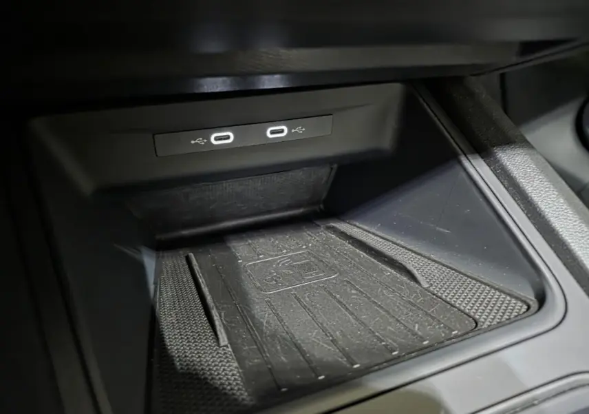 Gros plan sur la console centrale noire du CUPRA Formentor 2023, montrant deux prises USB-C éclairées et un tapis de recharge sans fil.