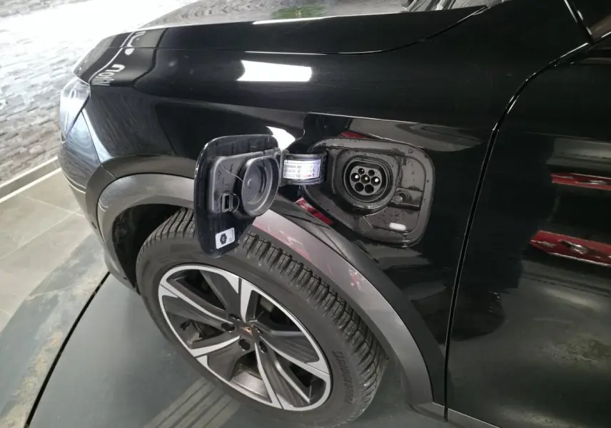 Prise de recharge ouverte côté avant gauche sur CUPRA Formentor noir, avec jante alliage 18 pouces visible.