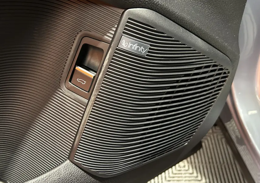 Gros plan sur le bouton d'ouverture du hayon et le haut-parleur Infinity dans l'habitacle du BYD SEAL U.