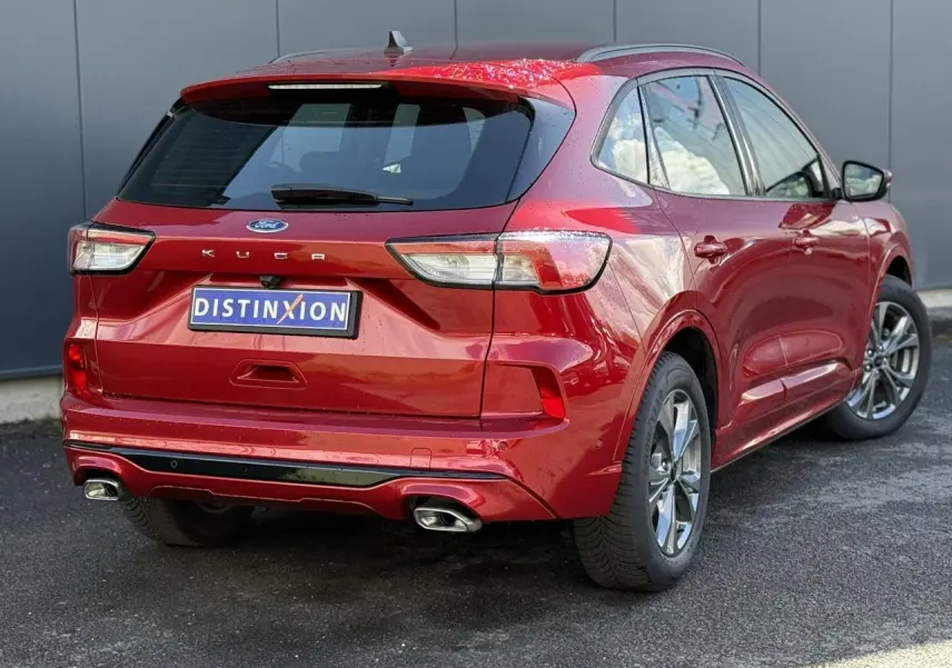 Vue 3/4 arrière droite du Ford Kuga rouge Lucifer 2024 avec double sortie d’échappement et jantes alliage 18 pouces.