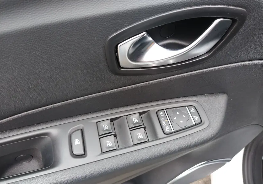 Gros plan sur la commande des vitres et la poignée intérieure côté conducteur du Renault Captur blanc 2017.