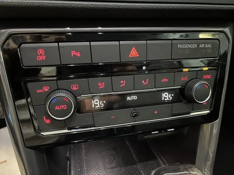 Panneau de commande de climatisation automatique du Volkswagen T-cross 1.0 TSI gris, affichant 19,5°C et fonctions activées.
