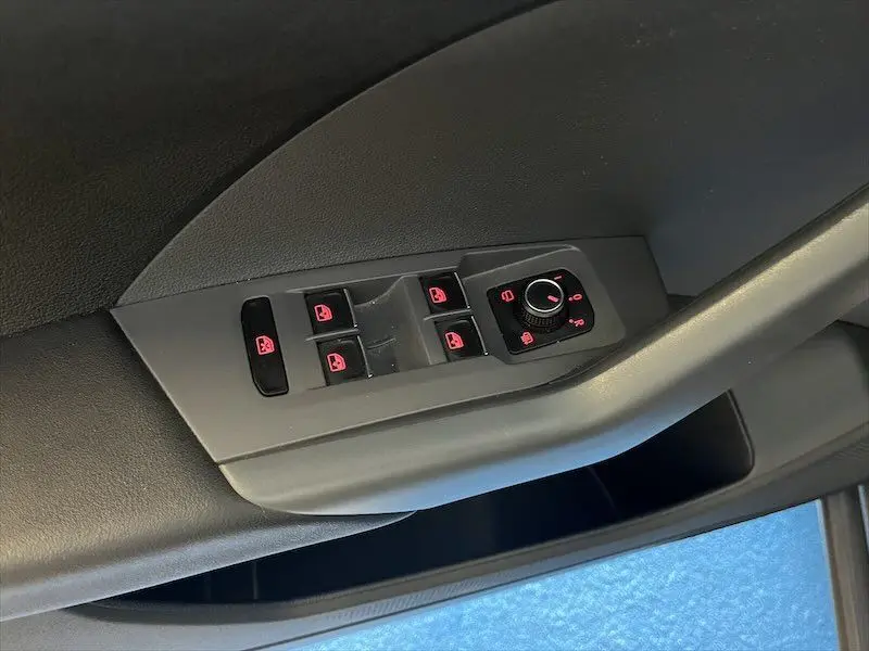 Panneau de commandes des vitres et rétroviseurs côté conducteur du Volkswagen T-Cross 1.0 TSI gris Limestone métallisé.