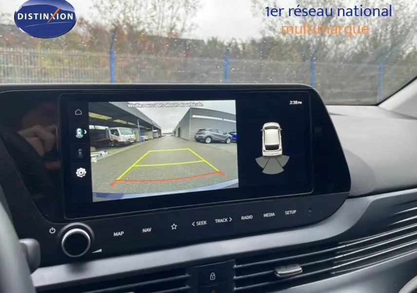 Vue intérieure sur l’écran multimédia affichant la caméra de recul avec lignes de guidage dans une Hyundai i20 gris Aurora.