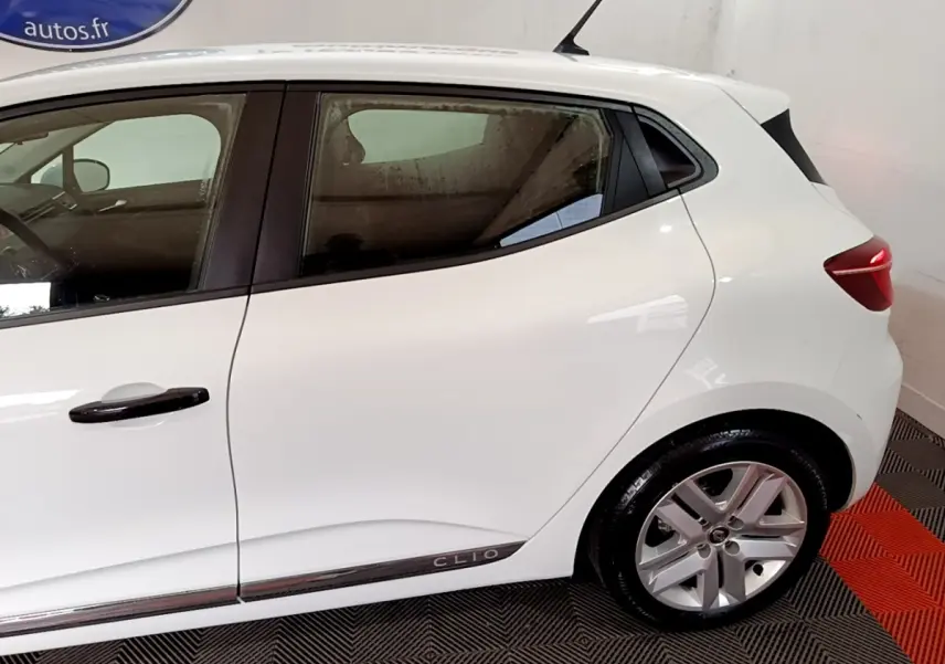 Profil côté gauche de la Renault Clio blanche Business SCe 65 2021, avec jantes alliage et poignées noires.