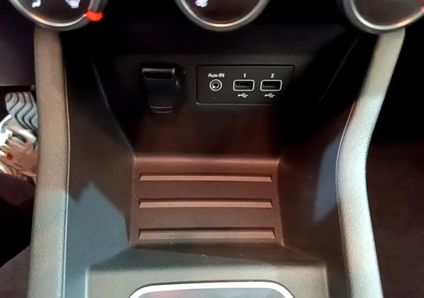Vue rapprochée de la console centrale noire de la Renault Clio Business avec ports USB et prise Aux-In visibles.
