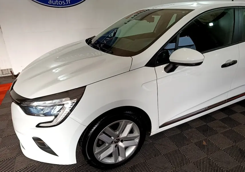 Vue 3/4 avant droit d'une Renault Clio Business blanche avec phares LED et jantes alliage argentées.