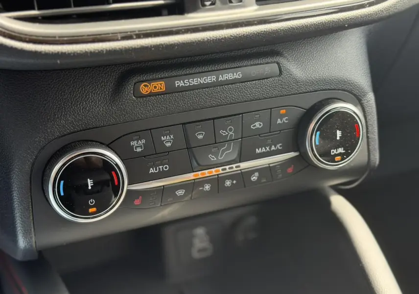 Gros plan sur la console de climatisation double zone du Ford Kuga 2024 avec commandes chauffantes et affichage lumineux.