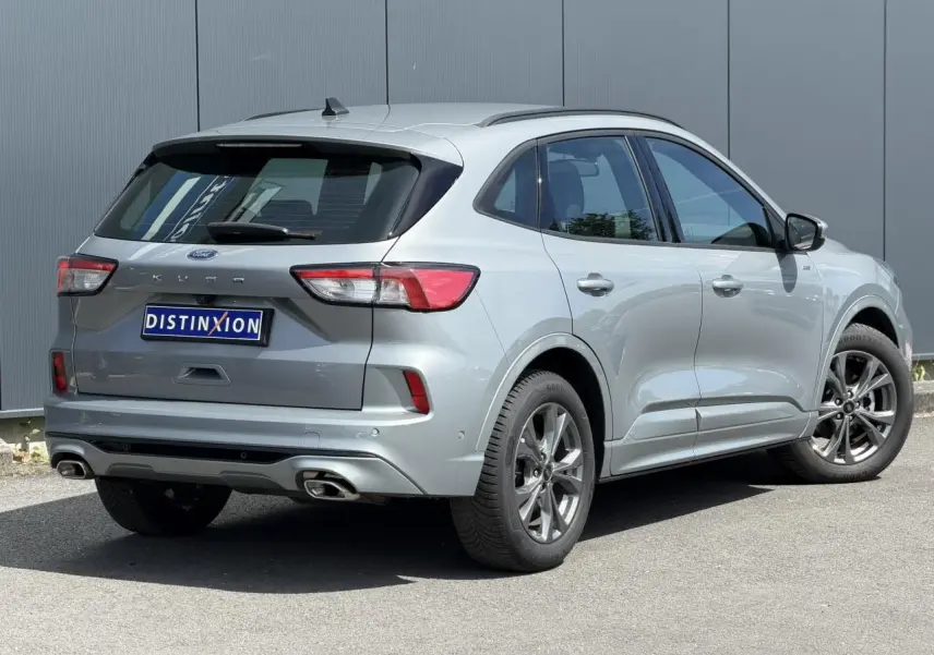 Vue 3/4 arrière droite d’un Ford Kuga 2.0 EcoBlue gris Solar avec double sortie d’échappement et jantes alliage 18 pouces.