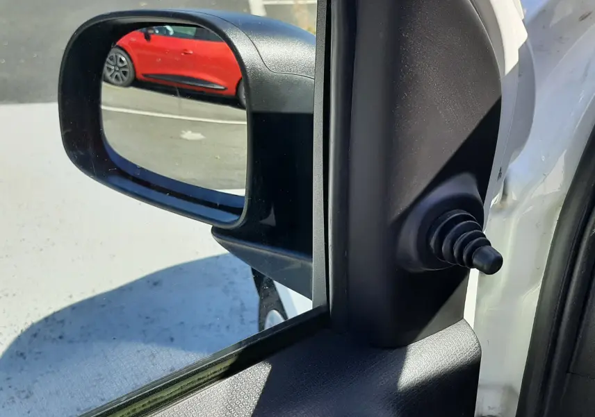Rétroviseur côté gauche d'une Fiat Panda blanche 2018, avec vue sur une voiture rouge en arrière-plan.