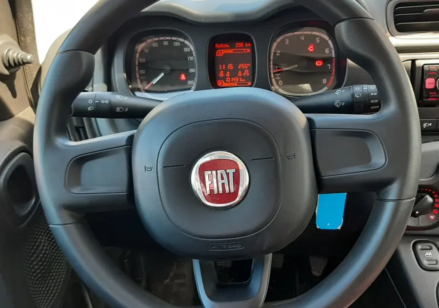 Vue intérieure centrée sur le volant noir de la Fiat Panda 1.2 69CH POP 2018 avec tableau de bord et commandes visibles.