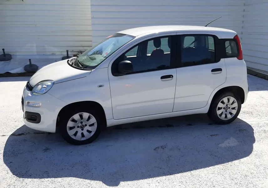 Vue 3/4 avant droite d'une Fiat Panda blanche 2018 essence avec plaque "OCCASION" et intérieur rouge visible.