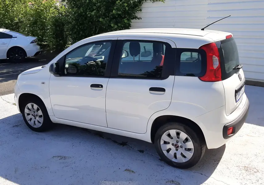 Vue latérale droite d'une Fiat Panda blanche 2018, compacte avec cinq portes et feux arrière rouges distinctifs.