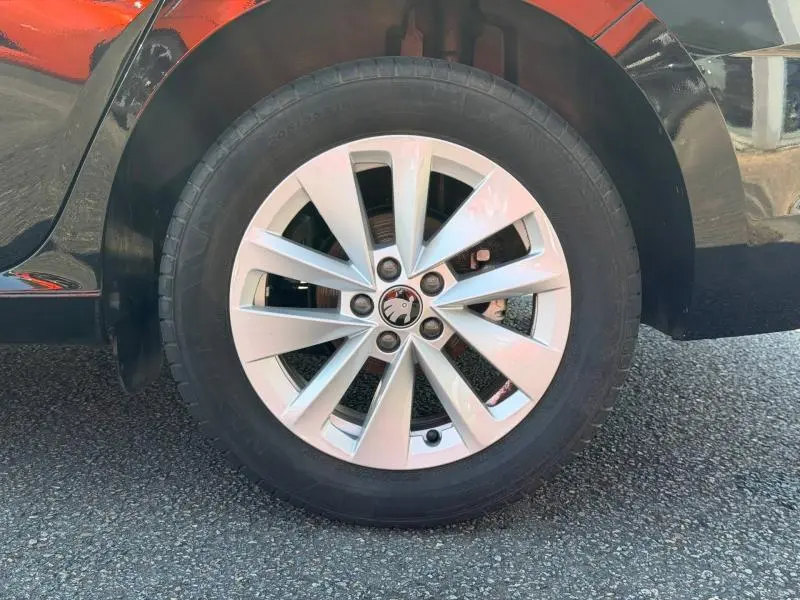 Gros plan sur la roue avant gauche avec jante alu argentée de la Skoda Scala noir Magic nacré.