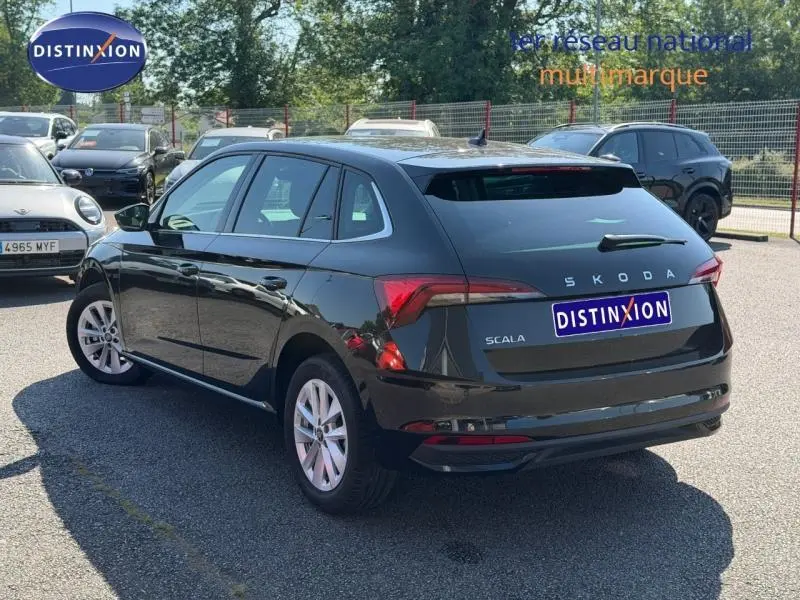 Vue 3/4 arrière droite d'une Skoda Scala noire Magic nacré avec feux arrière LED et jantes alu.
