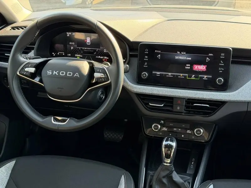 Vue intérieure du tableau de bord et volant cuir noir de la Skoda Scala 2025 avec écran tactile et commandes au volant.