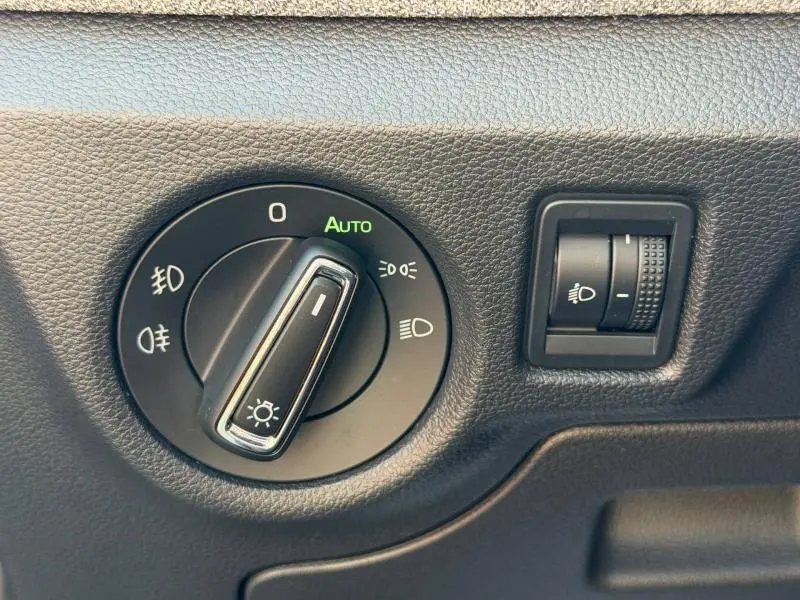 Gros plan sur le bouton de commande des phares et réglage d'intensité dans une Skoda Scala noir Magic nacré 2025.
