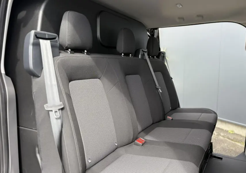 Vue intérieure côté droit montrant la banquette arrière en tissu rayé gris du Volkswagen Transporter T7 ProCab 2026.