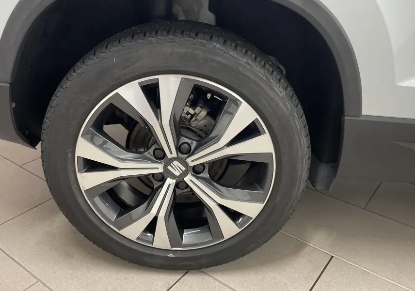 Gros plan sur la jante alliage 18 pouces usinée du côté arrière droit du SEAT Ateca blanc Nevada.