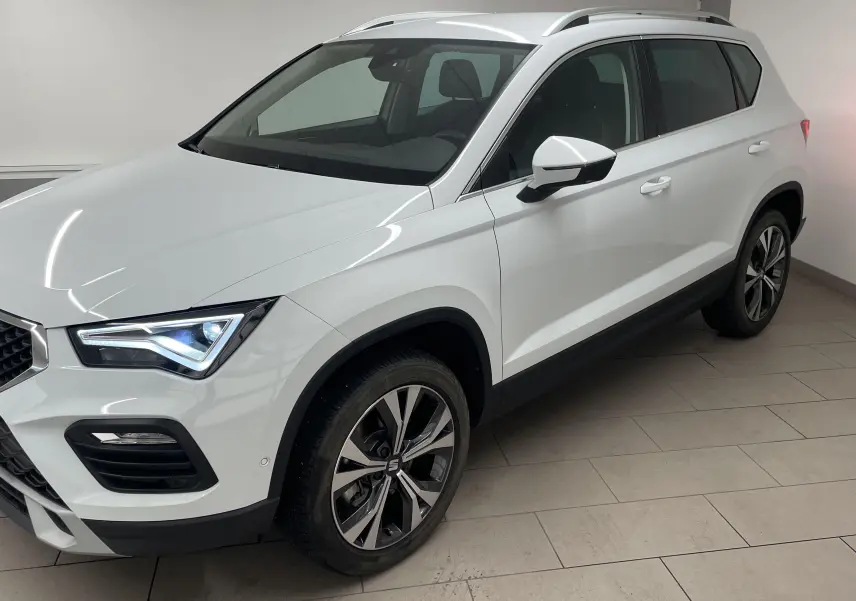 SEAT Ateca blanc Nevada en 3/4 avant droit, avec jantes alliage 18'' usinées et hayon électrique mains libres.