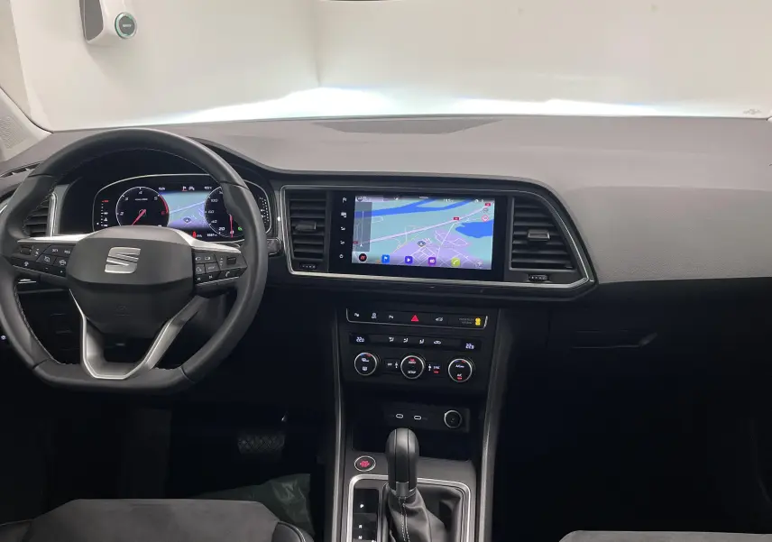 Vue intérieure du tableau de bord du SEAT Ateca 2.0 TDI blanc Nevada avec écran tactile et volant multifonction.
