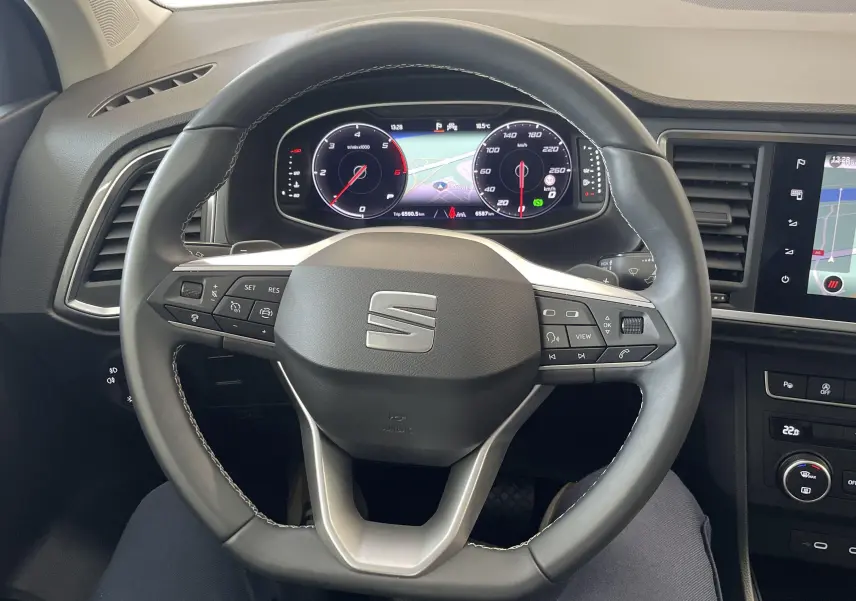 Vue intérieure centrée sur le volant du SEAT Ateca 2024 avec tableau de bord numérique et écran tactile multimédia.