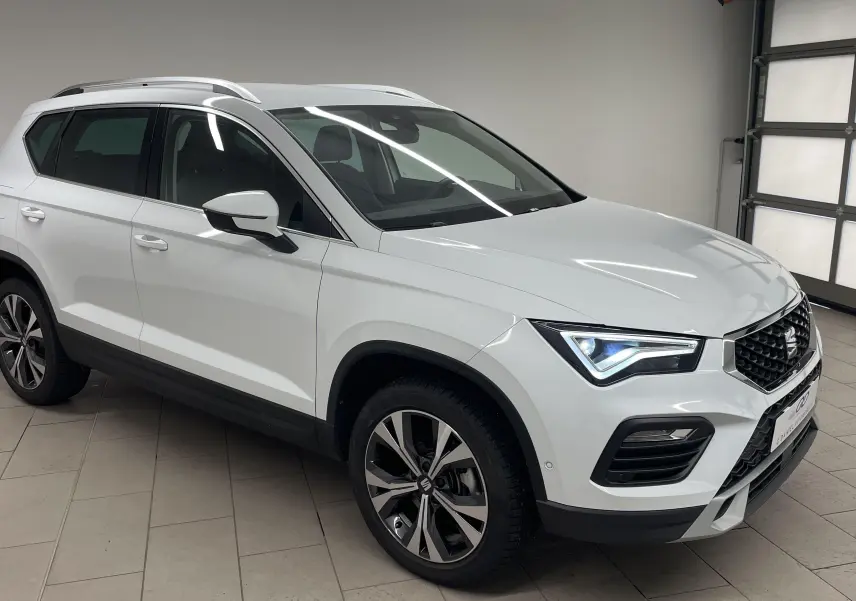 SEAT Ateca blanc Nevada en 3/4 avant droit, avec jantes alliage 18'' et hayon électrique mains libres.