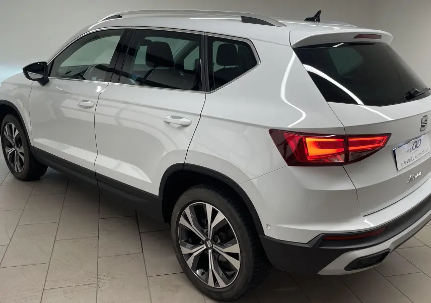 SEAT Ateca blanc Nevada vu en 3/4 arrière droit, avec jantes alliage 18'' et hayon électrique mains libres.