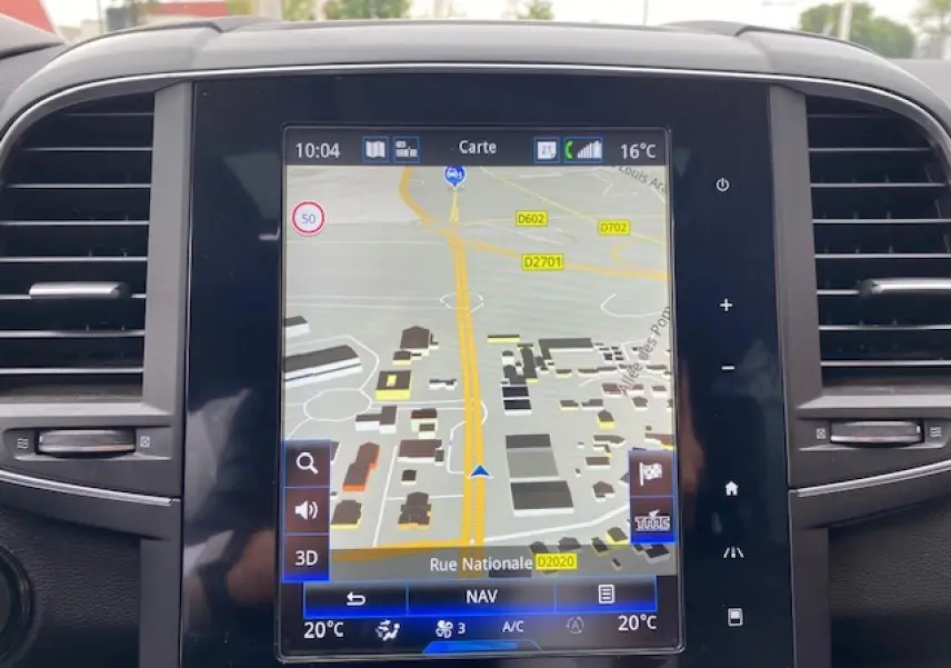 Vue rapprochée de l'écran tactile central du Renault Koleos blanc 2019 affichant la navigation GPS.