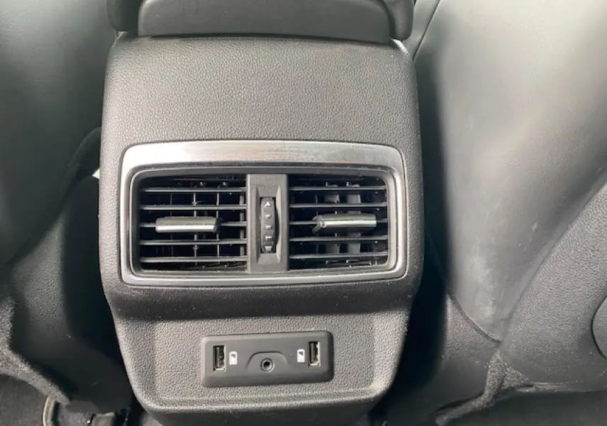 Détail des aérateurs arrière et ports USB noirs dans l'habitacle du Renault Koleos blanc 2019 Initiale Paris.