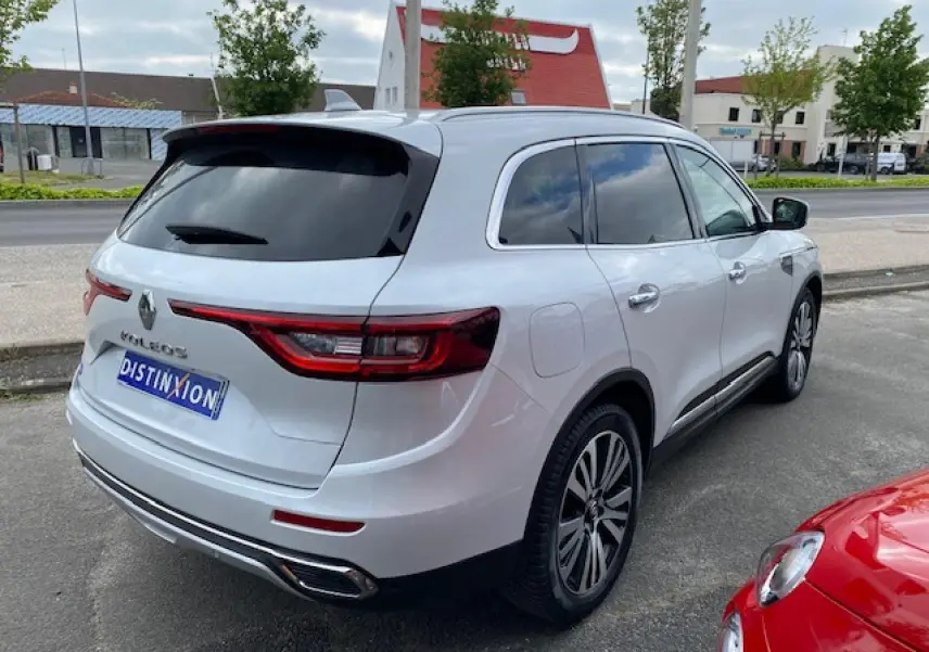 Renault Koleos blanc vu en 3/4 arrière droit, avec vitres teintées et feux arrière LED distinctifs.