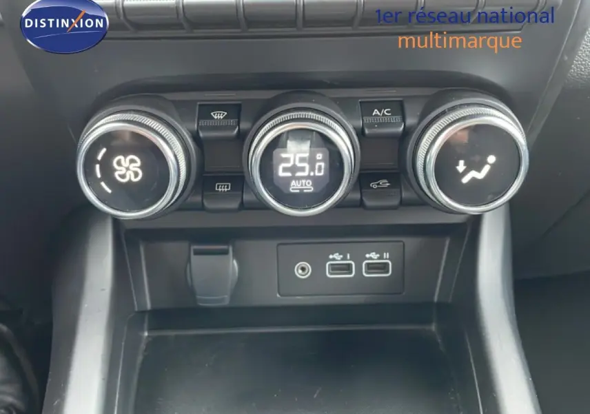 Gros plan sur la console centrale avec commandes de climatisation et ports USB du Renault Arkana bleu Zanzibar 2025.