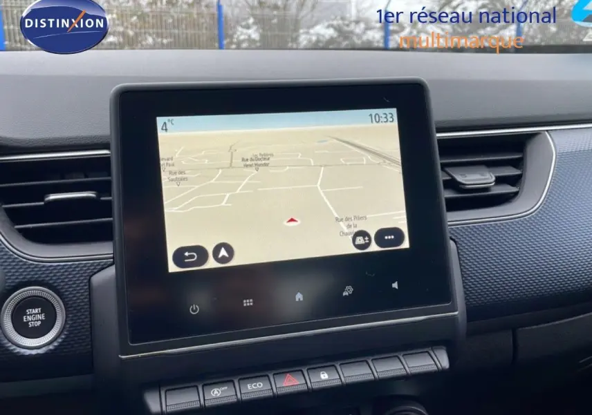 Vue intérieure centrée sur l'écran tactile du système de navigation du Renault Arkana bleu Zanzibar 2025.