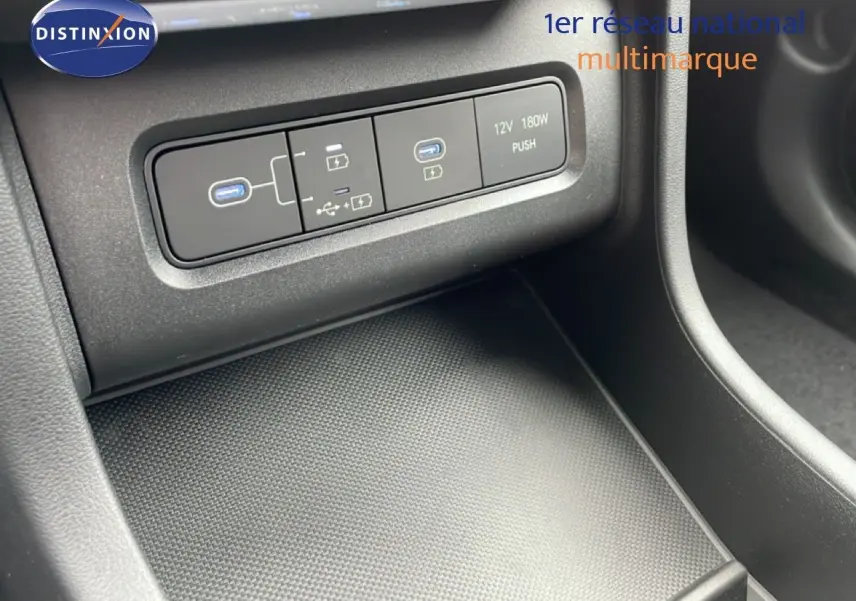 Gros plan sur la console centrale du Hyundai Tucson blanc Atlas, montrant les ports USB et prise 12V.