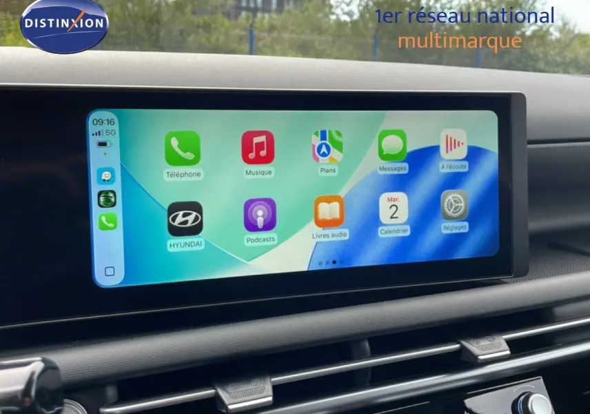 Écran tactile central affichant l'interface Apple CarPlay dans l'habitacle du Hyundai Tucson blanc Atlas 2026.