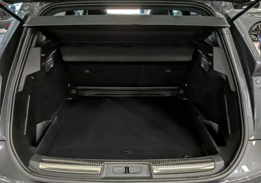 Coffre ouvert vu de l'arrière d'un DS7 2024 gris, montrant un espace de chargement propre et bien fini.