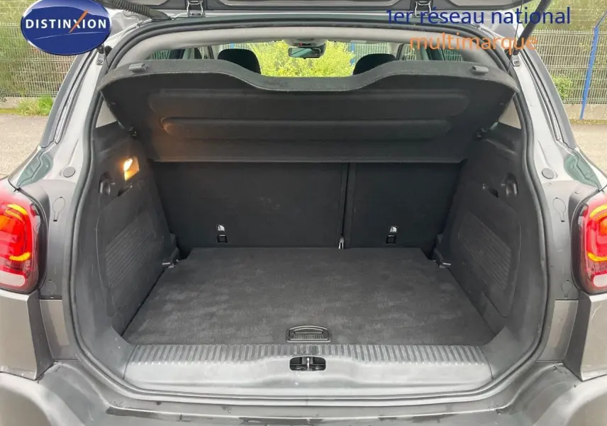 Coffre ouvert vu de l'arrière du Citroën C3 Aircross gris platinium métal, montrant un espace de chargement propre et spacieux.