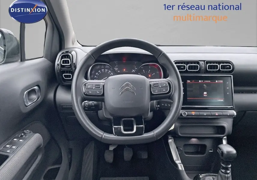 Vue intérieure centrée sur le volant et le tableau de bord du Citroën C3 Aircross gris platinium 2023, finition Shine.