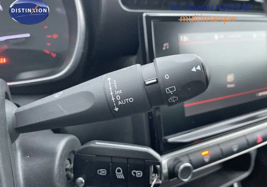 Gros plan sur la commande d'essuie-glace à gauche du volant dans l'habitacle du Citroën C3 Aircross gris platinium 2023.