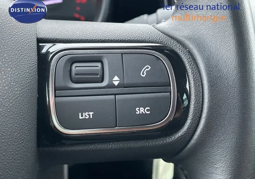 Gros plan sur les commandes au volant du Citroën C3 Aircross 2023, finition Shine, en tissu gris noir.