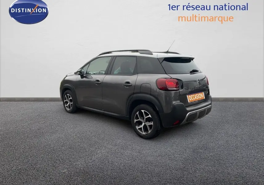 Vue 3/4 arrière droite d'un Citroën C3 Aircross gris platinium métallisé avec jantes bi-ton et toit noir.
