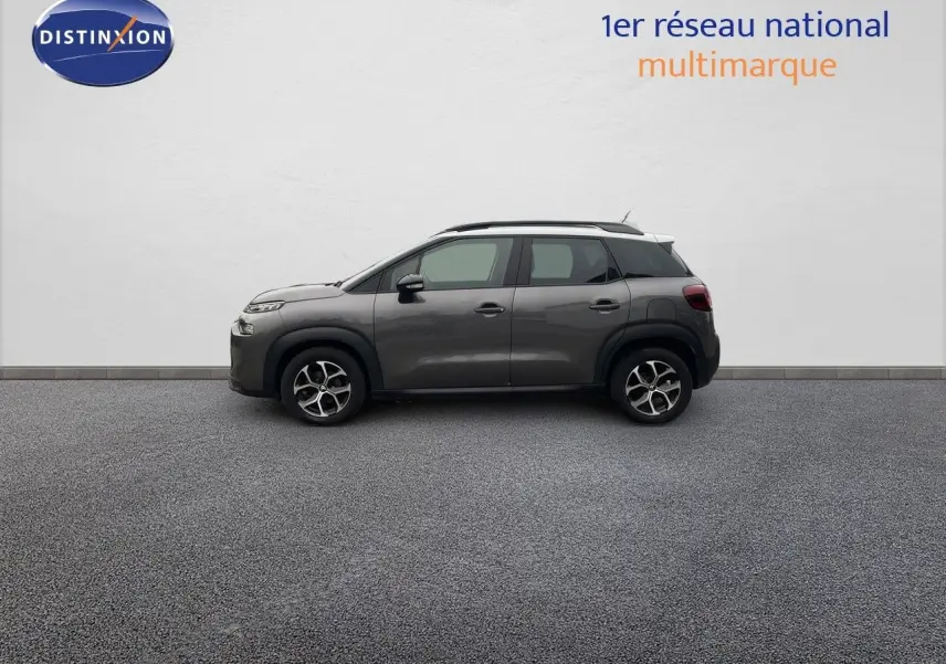 Profil droit d'un Citroën C3 Aircross gris platinium métal 2023 avec jantes bi-ton et toit blanc.